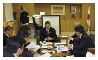 事例1　警視庁の担当者から説明を受ける国家公安委員会委員長（中央）