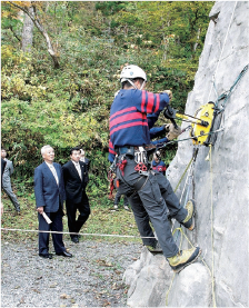 山岳警備隊隊員の遭難救助訓練を視察する国家公安委員会委員（左側）