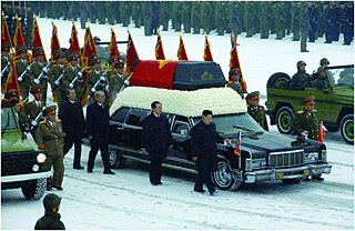 永訣式で霊柩車に寄り添う金正恩氏(時事）