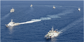 尖閣諸島周辺海域を航行する中国公船（写真右下）と海上保安庁の巡視船（写真提供：共同通信社）