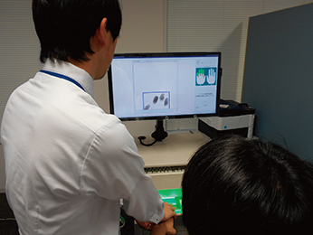 被疑者の指掌紋の採取状況（被疑者は模擬）